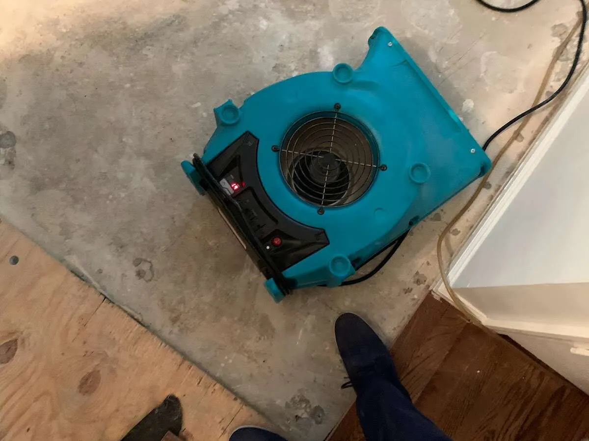 Air mover drying subfloor during Commercial Water Damage Restoration in Gonzales